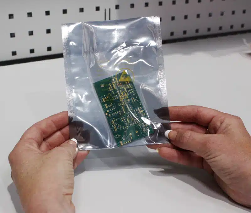 Operator holding static shielding bag with PCB inside. Bondline Electronics Limited.